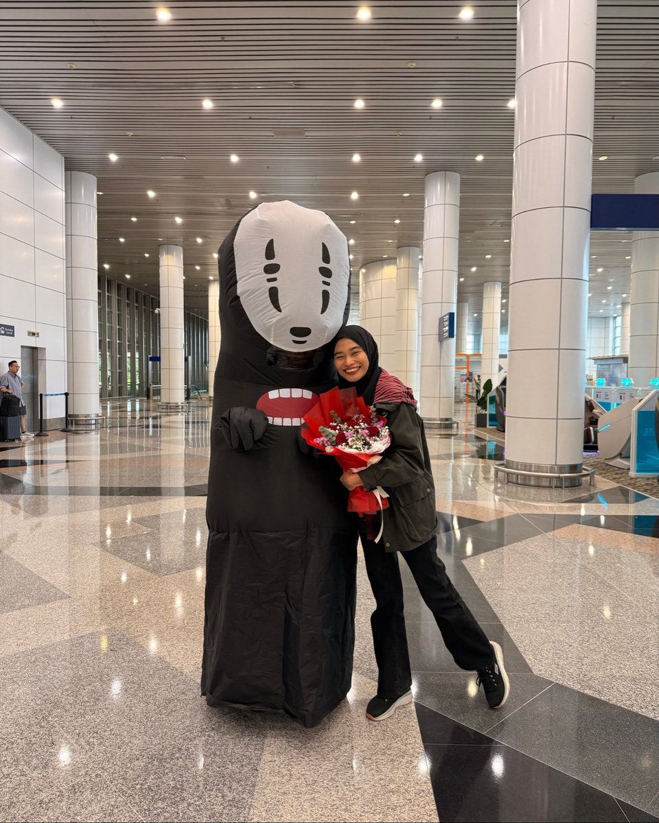 丈夫穿着无脸男吉祥物迎接妻子